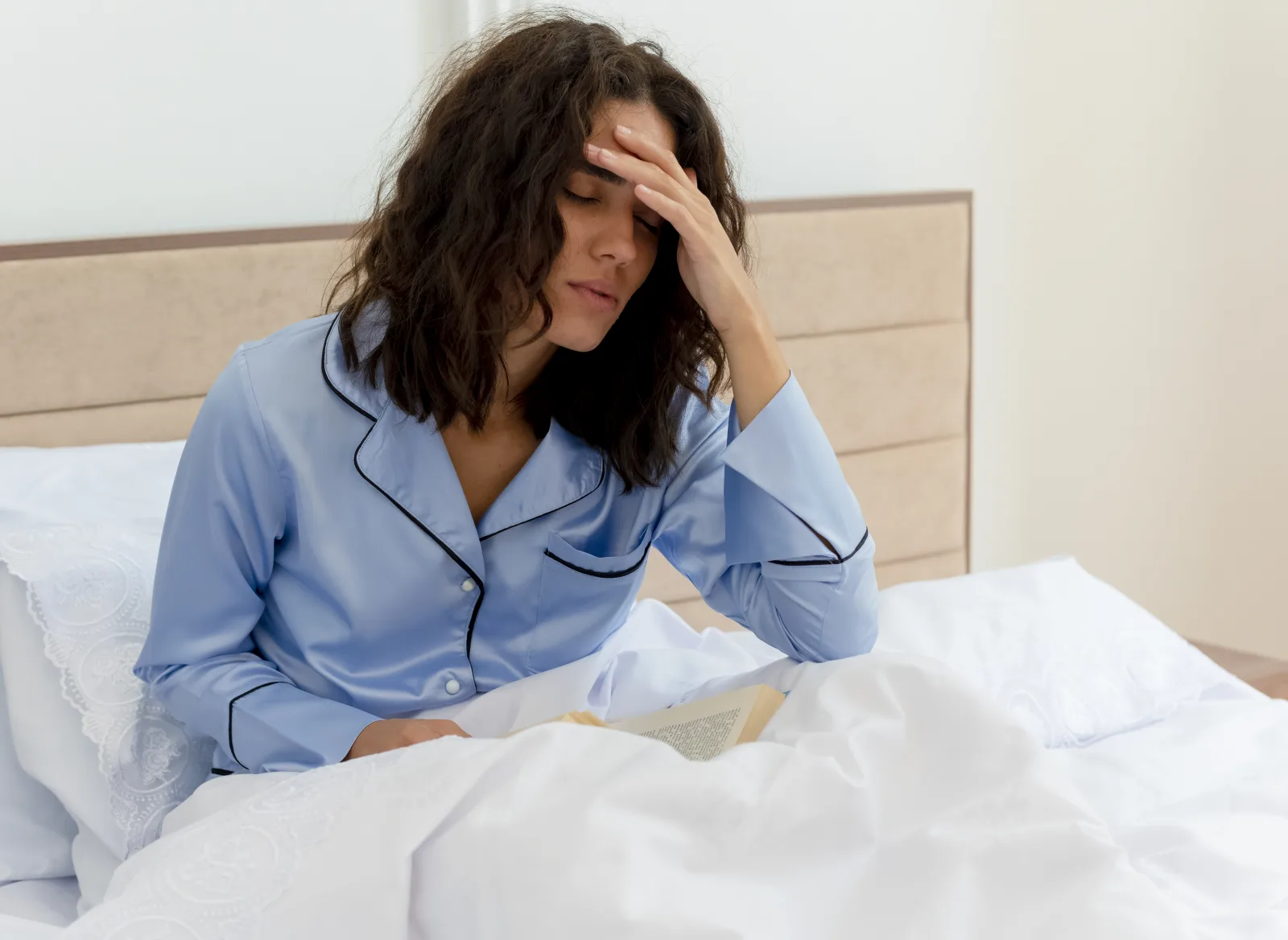 Femme éveillée dans son lit la nuit, les yeux ouverts, évoquant un état d’alerte maximale