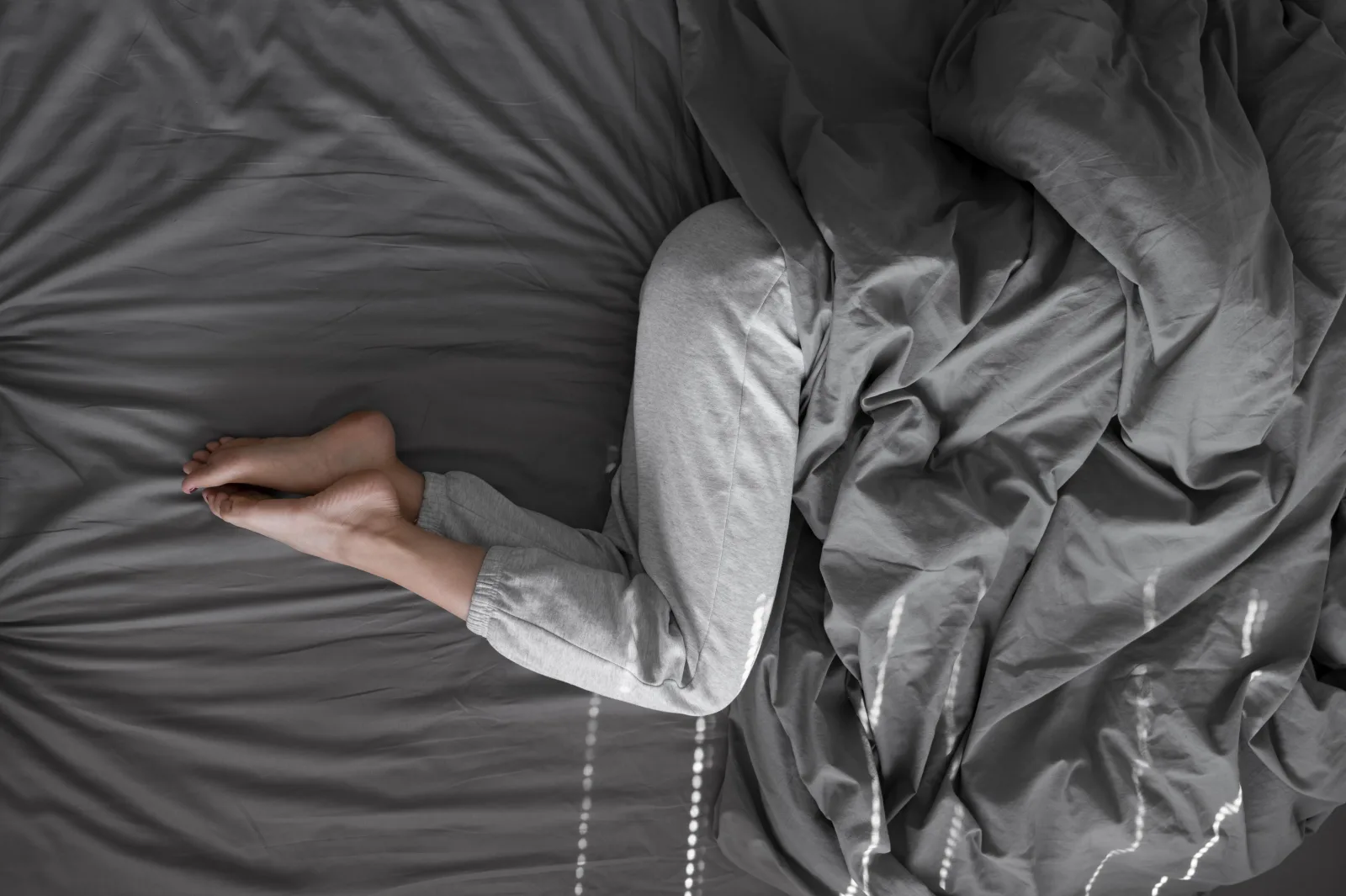 Femme réveillée dans son lit la nuit, évoquant un réveil nocturne lié à l’anxiété